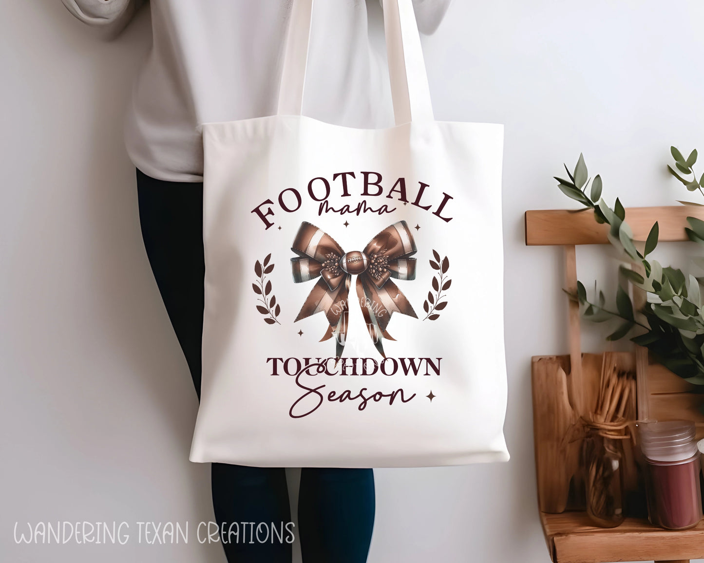 Made of linen, this stylish bag features a coquette bow design with the phrase "Football mama, Touchdown season".