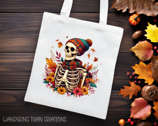 Made of durable linen, this tote bag features a sublimated design of a skeleton in a fall-themed ensemble, surrounded by beautiful flowers and leaves.