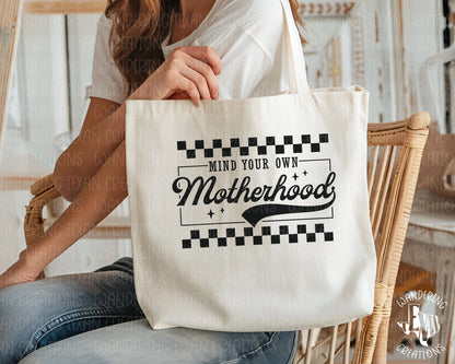 Carry it all with the Mind Your Own tote bag. This retro-designed bag features a cheeky "mind your own motherhood" phrase and a spacious interior to hold all your motherly essentials.