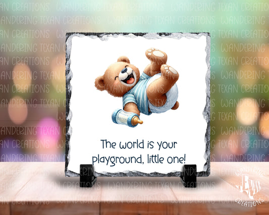 Introducing the Little One Slate Display, featuring a charming teddy bear design and the uplifting phrase "the world is your playground, little one!"