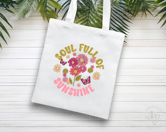 Experience the magic of summertime with our Meadow Magic Tote Bag. The vibrant sublimation design features a picturesque bundle of summer flowers alongside graceful butterflies and the inspiring phrase "soul full of sunshine".