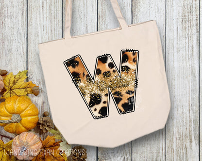 Made from durable canvas, it features a unique sublimated design in a peach-to-brown cow print pattern and gold glitter accents. Choose your initial for a truly one-of-a-kind bag.