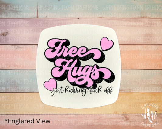 This quirky magnet features the phrase "free hugs" with a playful twist - "just kidding fuck off" - to add some humor to your daily routine. 