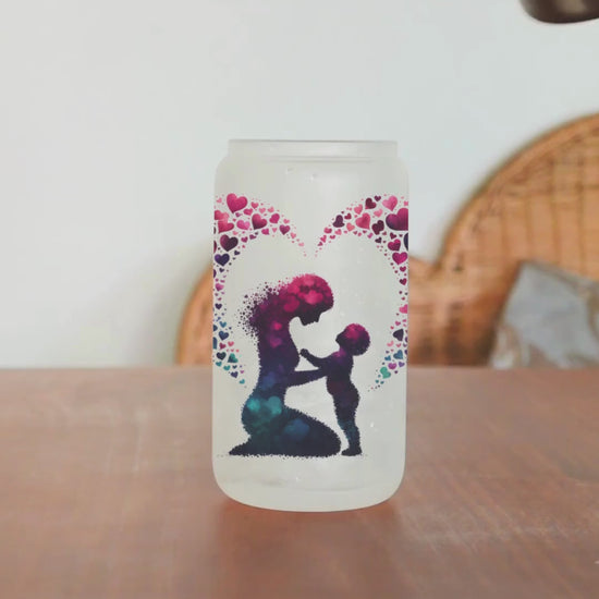 This frosted glass tumbler features a unique silhouette design of a mom and child made of overlapping hearts, with a heart surrounding both.