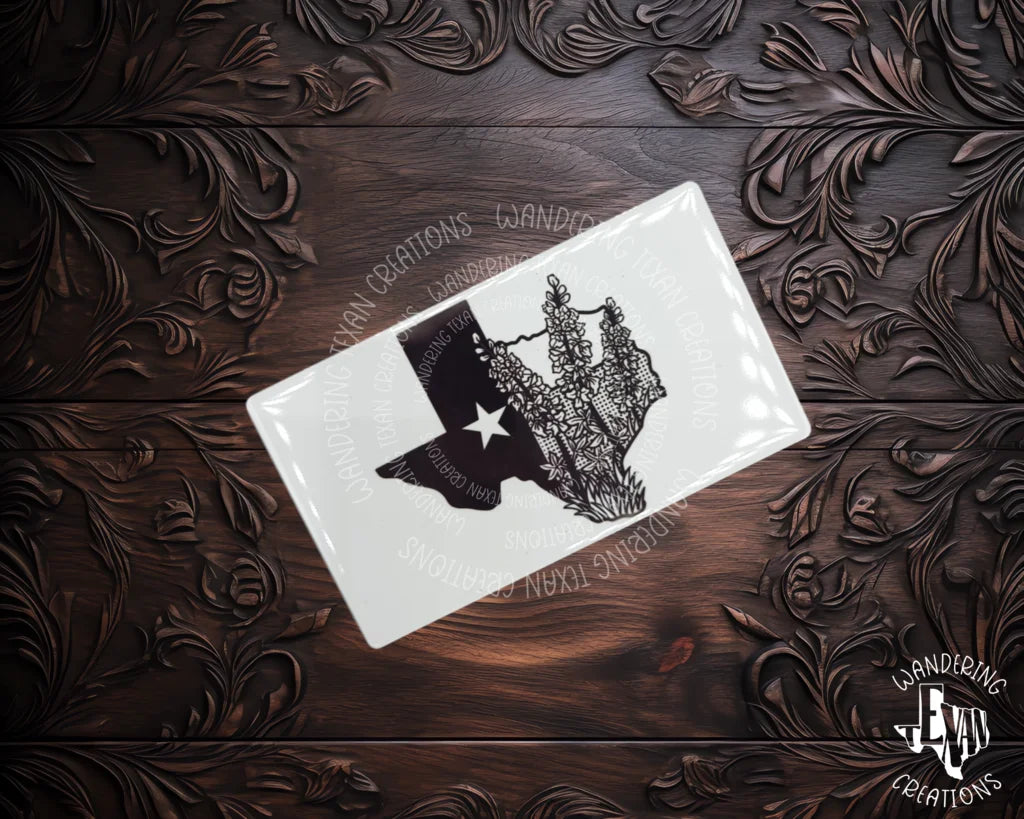 Stick to your love for Texas with this bluebonnet-adorned magnet featuring the state silhouette and flag. A sublime addition to your fridge. Yee-haw!