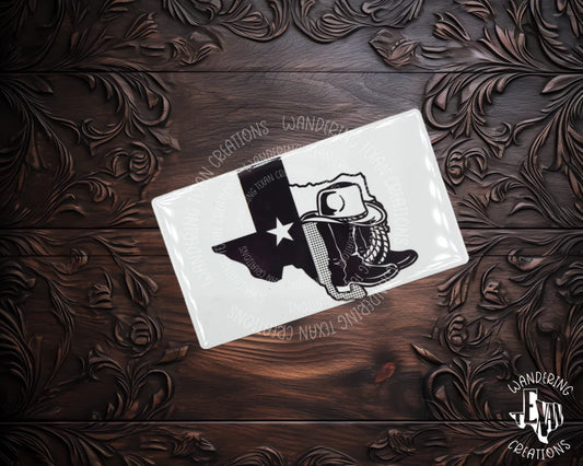 This quirky magnet features the iconic silhouette of the Lone Star State with a flag design behind a pair of cowboy boots and a hat on top.